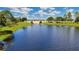 Picturesque view of a serene pond with a decorative bridge and lush green surroundings at 5214 Lake Venice Dr, Wimauma, FL 33598