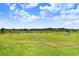 Picturesque vacant lot offers a serene setting with lush greenery and beautiful blue skies at 5214 Lake Venice Dr, Wimauma, FL 33598