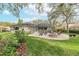 Home's back view, showcasing patio, pool, and lush landscape at 6017 Hammock Hill Ave, Lithia, FL 33547