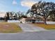 Ranch-style home with a long driveway and a large tree in the front yard at 6040 Antrim St, New Port Richey, FL 34653