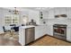 Modern white kitchen with stainless steel appliances and breakfast bar at 7120 Hideaway Trl, New Port Richey, FL 34655