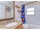 Bathroom with granite countertop, bathtub, and dinosaur-themed decor at 7136 Colony Pointe Dr, Riverview, FL 33578