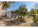 Back exterior view with a rock garden, palm tree, hot tub, and screened in porch at 8307 Boxwood Dr, Tampa, FL 33615