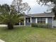 Gray house with white trim, landscaping, and palm tree at 8307 Boxwood Dr, Tampa, FL 33615