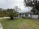 Gray house with palm tree and well-maintained lawn at 8307 Boxwood Dr, Tampa, FL 33615