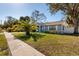 Attractive single-story home featuring a well-manicured lawn, lush landscaping, and blue exterior at 8307 Boxwood Dr, Tampa, FL 33615