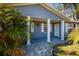 Charming front porch with white pillars, complementing the blue exterior and stone pathway at 8307 Boxwood Dr, Tampa, FL 33615