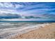 Beachfront view with ocean waves and partly cloudy sky at 8581 W Gulf Blvd, Treasure Island, FL 33706