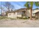 Side view of a light beige cottage with a sandy yard at 8581 W Gulf Blvd, Treasure Island, FL 33706