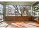 Empty screened porch with wood floors and view of trees at 8581 W Gulf Blvd, Treasure Island, FL 33706