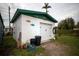 Detached garage with white door, green trim, and unique decor at 8742 Narcissus Ave, Seminole, FL 33777