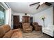 Living room featuring two brown leather chairs, a glass-front cabinet, and wood-look floors at 8742 Narcissus Ave, Seminole, FL 33777