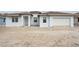 Newly constructed light blue house with white garage doors at 9032 Evelyn Rd, Englewood, FL 34224