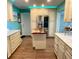 Modern kitchen with island, stainless steel appliances, and teal accents at 9920 34Th N Way, Pinellas Park, FL 33782