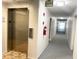 Clean and well-lit hallway with elevator access and fire safety features at 100 Waverly Way # 201, Clearwater, FL 33756