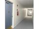 Apartment building hallway with carpeted floor, fire extinguisher, and apartment doors at 100 Waverly Way # 201, Clearwater, FL 33756