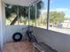 Relaxing screened balcony with tiled floor, bicycle, and tire, offering scenic views at 100 Waverly Way # 201, Clearwater, FL 33756