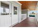 Covered deck with white doors and wooden flooring at 13477 Irwin Dr, Port Charlotte, FL 33953