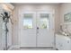Bright entryway with white double doors and decorative accents at 13477 Irwin Dr, Port Charlotte, FL 33953