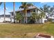 Elevated home with palm trees and grassy lawn at 13477 Irwin Dr, Port Charlotte, FL 33953