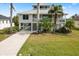 Two-story house with a metal roof and tropical landscaping at 13477 Irwin Dr, Port Charlotte, FL 33953