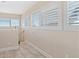 Bright hallway with white shutters and wood-look tile flooring at 13477 Irwin Dr, Port Charlotte, FL 33953