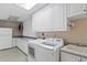 Laundry room with white cabinets, washer, dryer, and sink at 13477 Irwin Dr, Port Charlotte, FL 33953