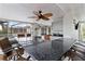 Outdoor kitchen with granite countertop, seating, and ceiling fan at 13477 Irwin Dr, Port Charlotte, FL 33953