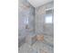 Walk-in shower with blue marble tile and built-in seat at 13477 Irwin Dr, Port Charlotte, FL 33953