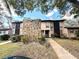 Exterior view of condo building with stone accents and landscaping at 1400 Tarpon Woods Blvd # H6, Palm Harbor, FL 34685