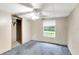 Bedroom with blue carpet, ceiling fan, and a window at 14927 Balough Rd, Odessa, FL 33556