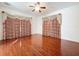 Large bedroom with hardwood floors, ceiling fan and elegant curtains at 1542 Deerbourne Dr, Wesley Chapel, FL 33543