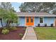 Close-up view of the home's exterior, showcasing the orange front door and landscaping at 1662 Spottswood Cir, Palm Harbor, FL 34683