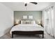 Spacious bedroom with king bed, grey carpet, and sage green accent wall at 21428 Darter Rd, Land O Lakes, FL 34638