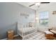 Bedroom with a crib, rocking chair, and light grey walls at 21428 Darter Rd, Land O Lakes, FL 34638