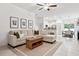 Open living room with L-shaped sofa and access to kitchen and dining areas at 21428 Darter Rd, Land O Lakes, FL 34638
