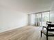 Spacious living area featuring light wood flooring and access to balcony at 220 Belleview Blvd # 101, Belleair, FL 33756