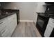 Compact kitchen featuring granite countertops, black appliances, and sleek white cabinetry at 2621 Cove Cay Dr # 205, Clearwater, FL 33760