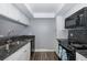 Modern kitchen features granite countertops, white cabinets, and black appliances at 2621 Cove Cay Dr # 205, Clearwater, FL 33760