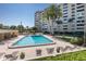 Inviting community pool with lounge chairs and surrounding building at 2621 Cove Cay Dr # 205, Clearwater, FL 33760