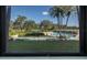 Community pool with surrounding lawn and palm trees at 2621 Cove Cay Dr # 205, Clearwater, FL 33760