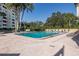 Resort-style pool with lounge chairs and surrounding trees at 2621 Cove Cay Dr # 205, Clearwater, FL 33760