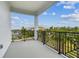 Spacious balcony featuring black metal railings with neighborhood views of trees and roofs at 3027 Bermuda Sloop Cir, Ruskin, FL 33570
