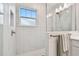Elegant bathroom featuring a glass shower enclosure with window, and marble tiling at 3027 Bermuda Sloop Cir, Ruskin, FL 33570