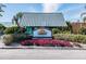 Charming entrance sign for 'Sunset Grill & Beach Bar', surrounded by lush greenery and vibrant flowers at 3027 Bermuda Sloop Cir, Ruskin, FL 33570