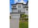 Charming three-story townhome offers a well-manicured lawn, complemented by a paved driveway leading to a spacious two-car garage at 3027 Bermuda Sloop Cir, Ruskin, FL 33570