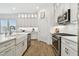 Bright kitchen with white cabinets, stainless steel appliances, and a farmhouse sink at 3027 Bermuda Sloop Cir, Ruskin, FL 33570