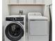 Laundry room features an Electrolux washer and dryer and overhead cabinets for storage at 3027 Bermuda Sloop Cir, Ruskin, FL 33570