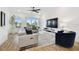 Bright living room with wood floors, large windows, a comfortable couch, and stylish decor at 3027 Bermuda Sloop Cir, Ruskin, FL 33570