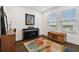 Cozy living room features a piano, stylish rug, and plenty of natural light from large windows at 3027 Bermuda Sloop Cir, Ruskin, FL 33570